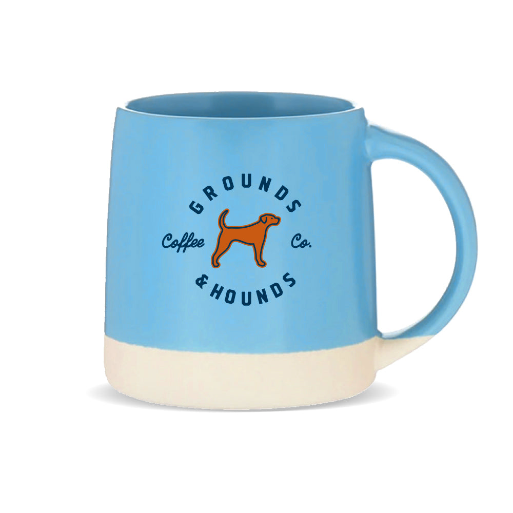 blue mug with grounds and hounds logo plus brown dog