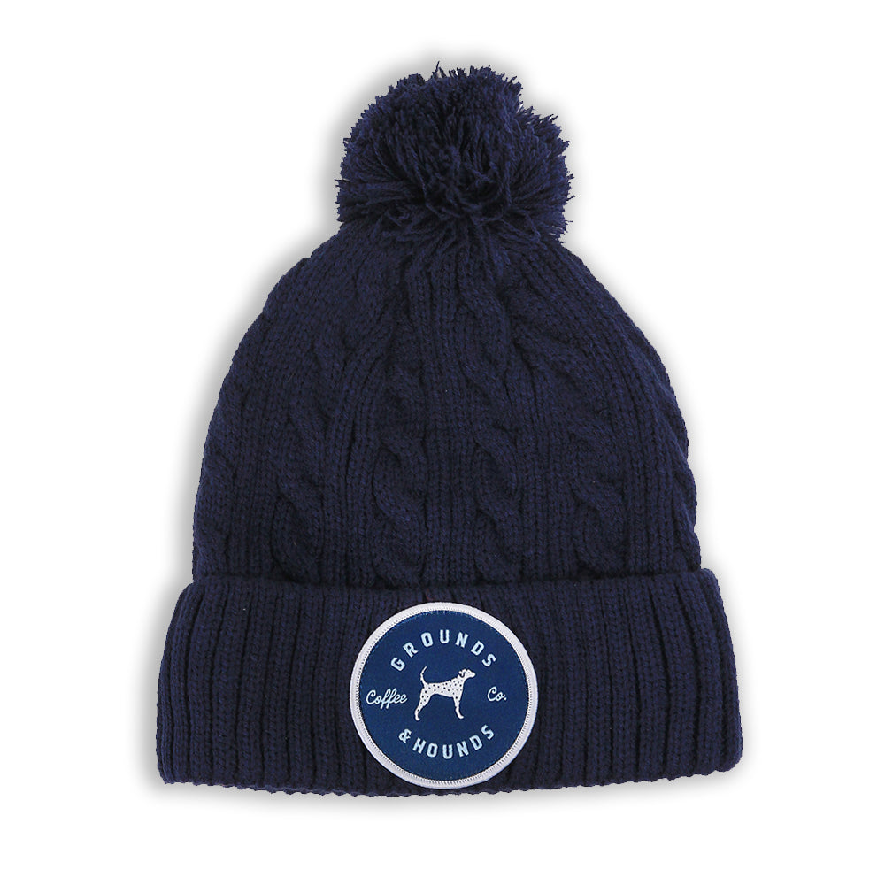 navy blue knit beanie with puff ball and patch